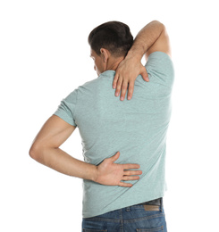 Man suffering from pain in back on white background. Visiting orthopedist