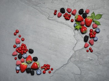 Photo of Different fresh berries on grey background, flat lay. Space for text