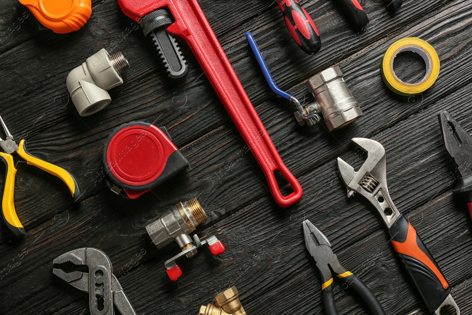Photo of Flat lay composition with plumber's tools on wooden background
