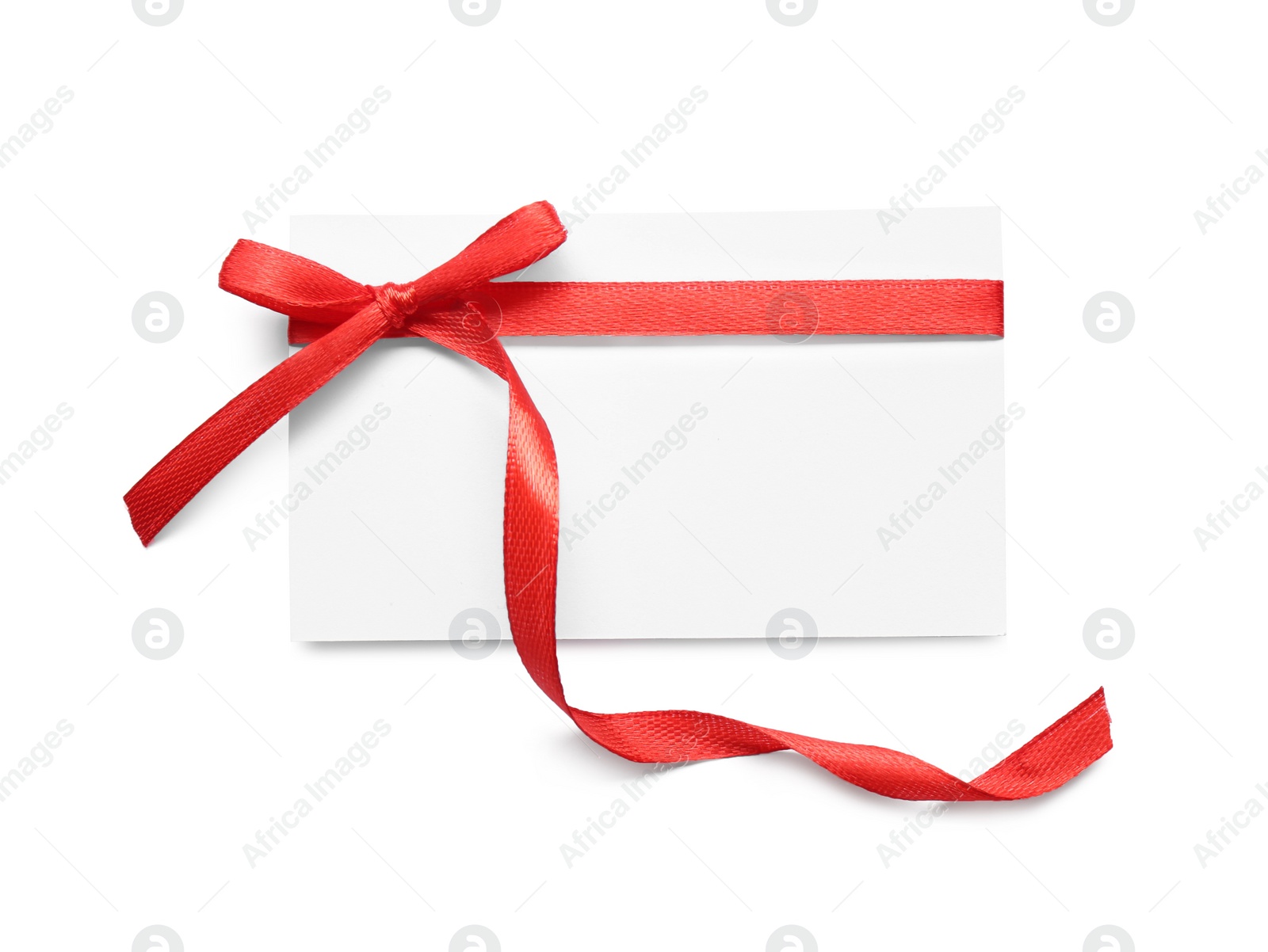 Photo of Blank gift tag with red satin ribbon on white background, top view