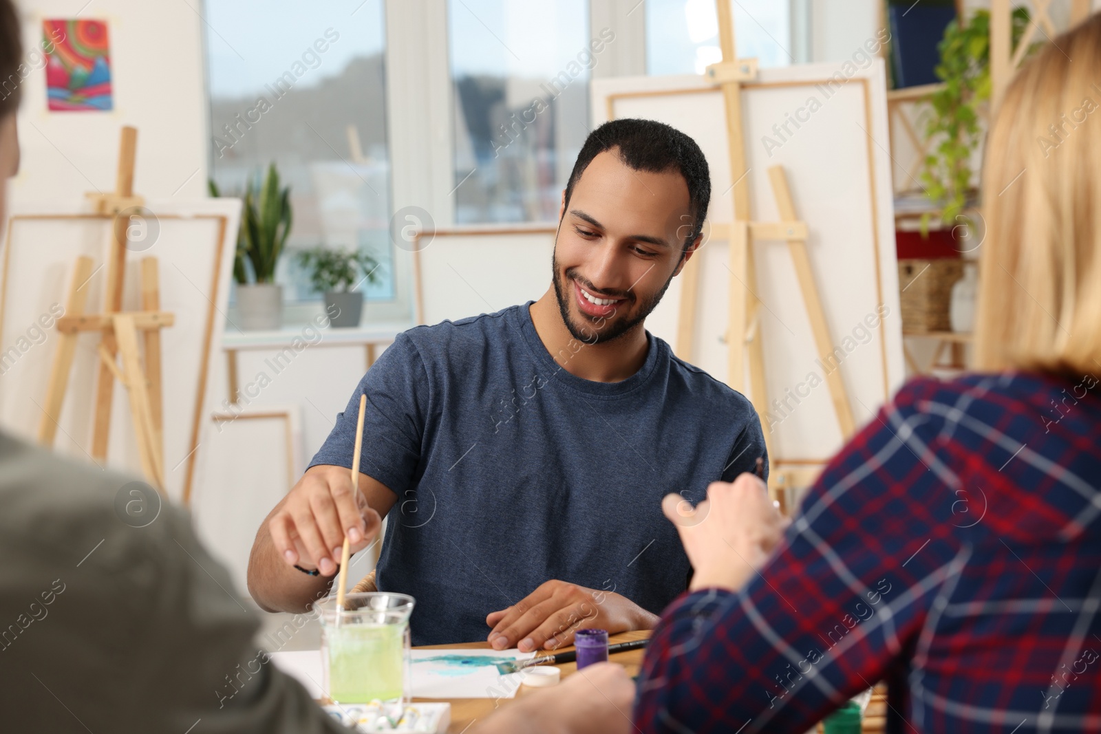 Photo of Group of students attending painting class in studio. Creative hobby