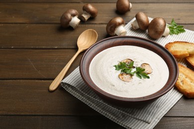 Photo of Fresh homemade mushroom soup served on wooden table. Space for text
