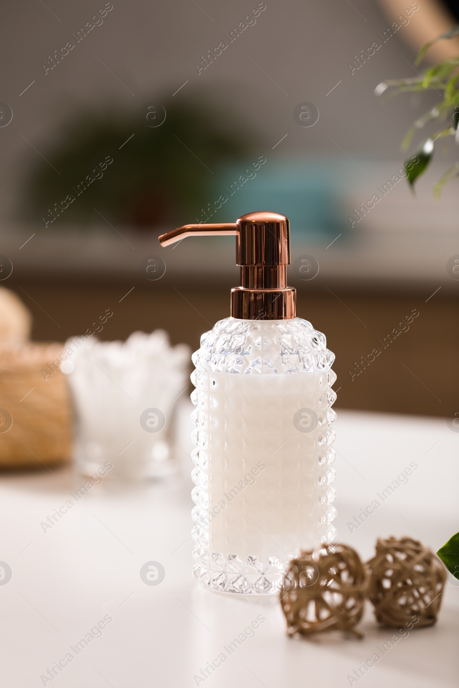 Photo of Stylish soap dispenser on white table indoors