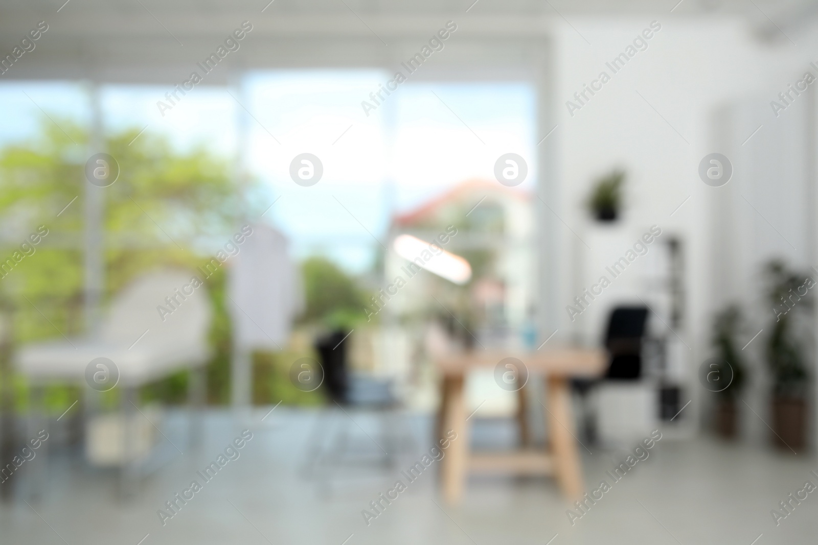 Photo of Blurred view of modern medical office with doctor's workplace. Interior design