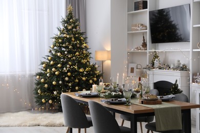 Photo of Christmas table setting with festive decor and dishware in living room