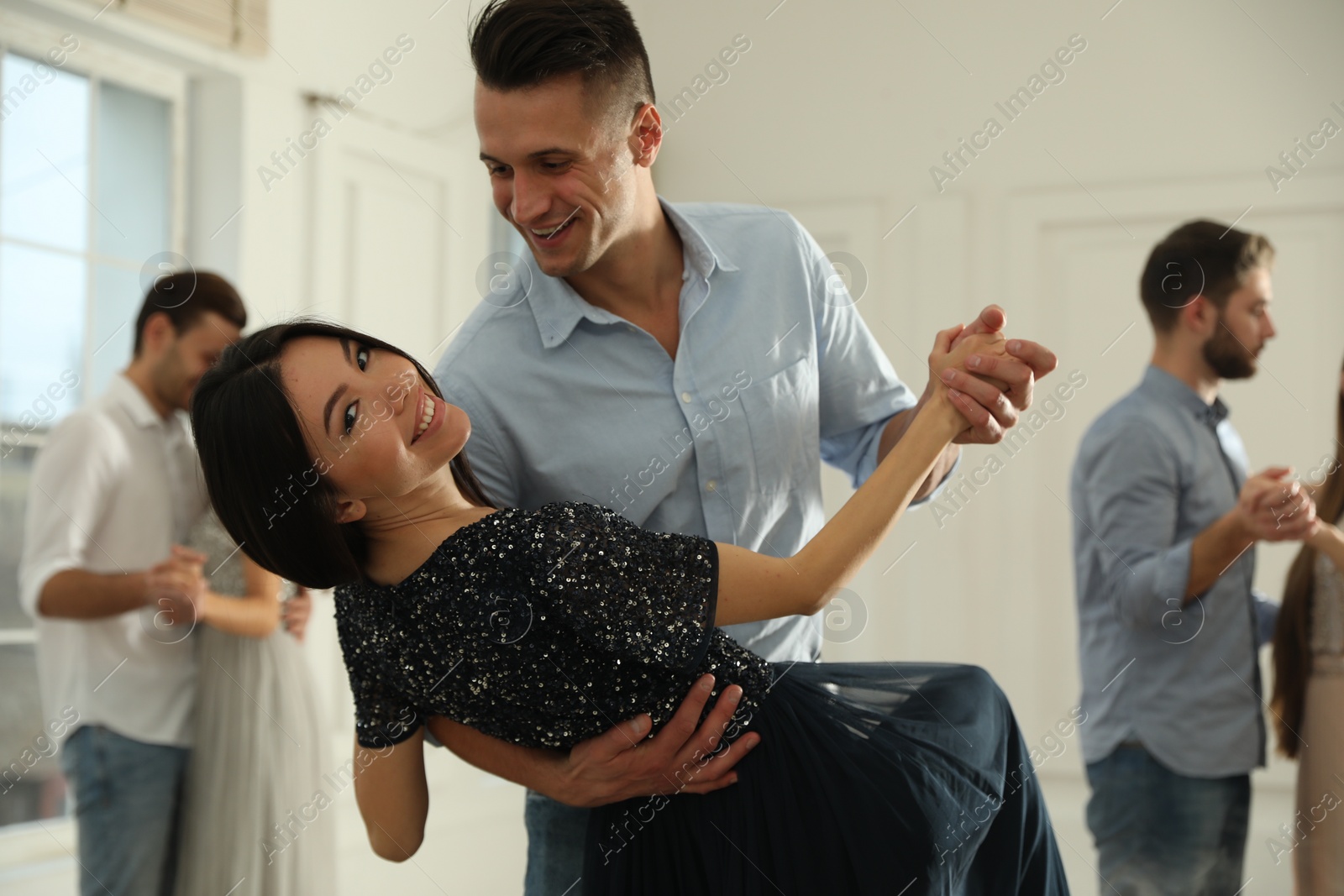 Photo of Lovely young couple dancing together at party