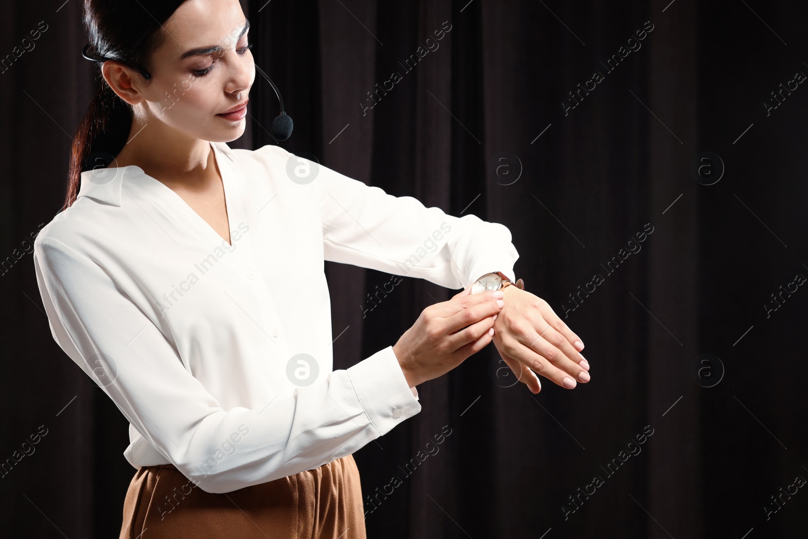 Photo of Motivational speaker with headset performing on stage. Space for text