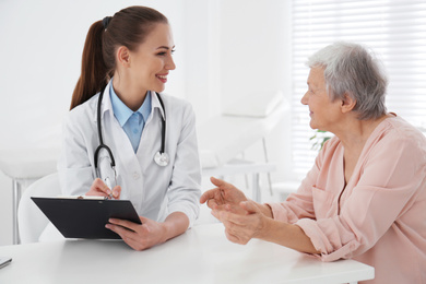 Doctor examining senior patient in modern office