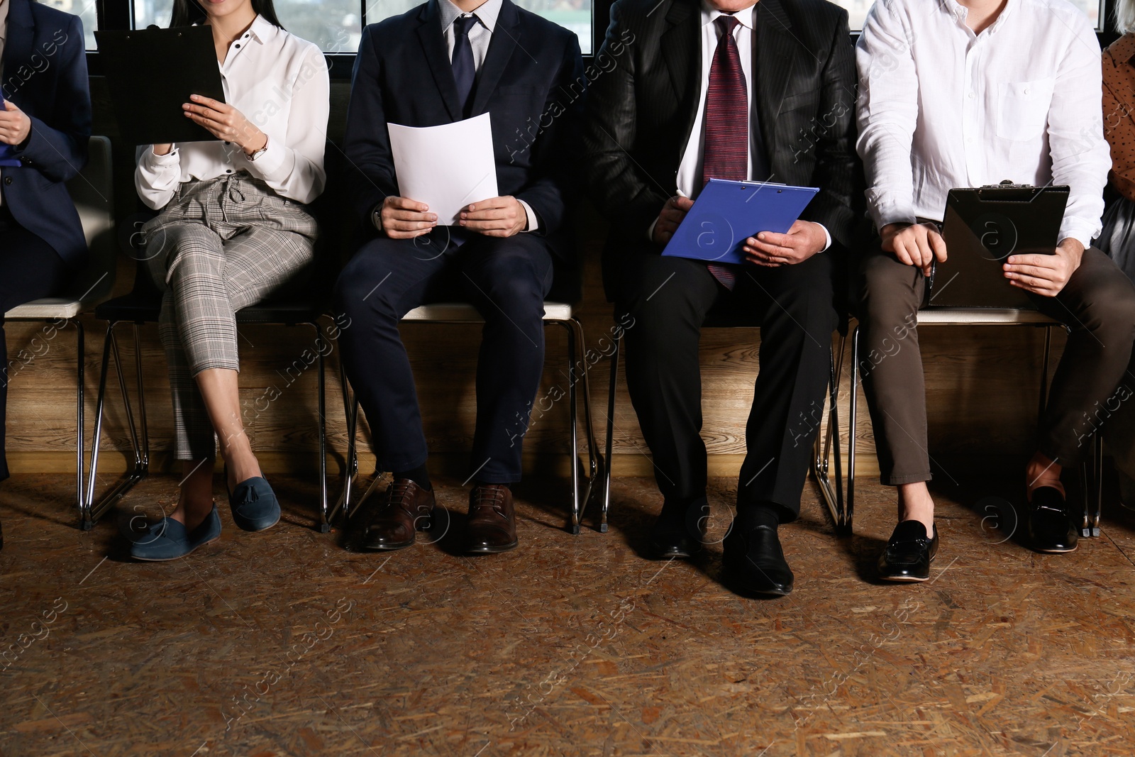 Photo of People waiting for job interview in office hall, closeup