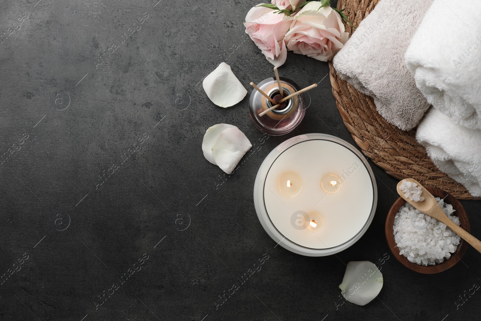 Photo of Flat lay composition with different spa products and rose flowers on grey table. Space for text