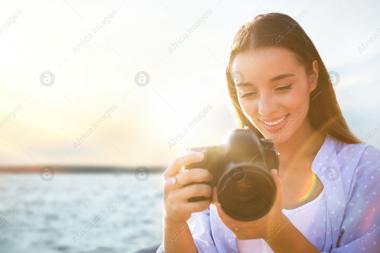 Photo of Young photographer taking picture with professional camera outdoors. Space for text