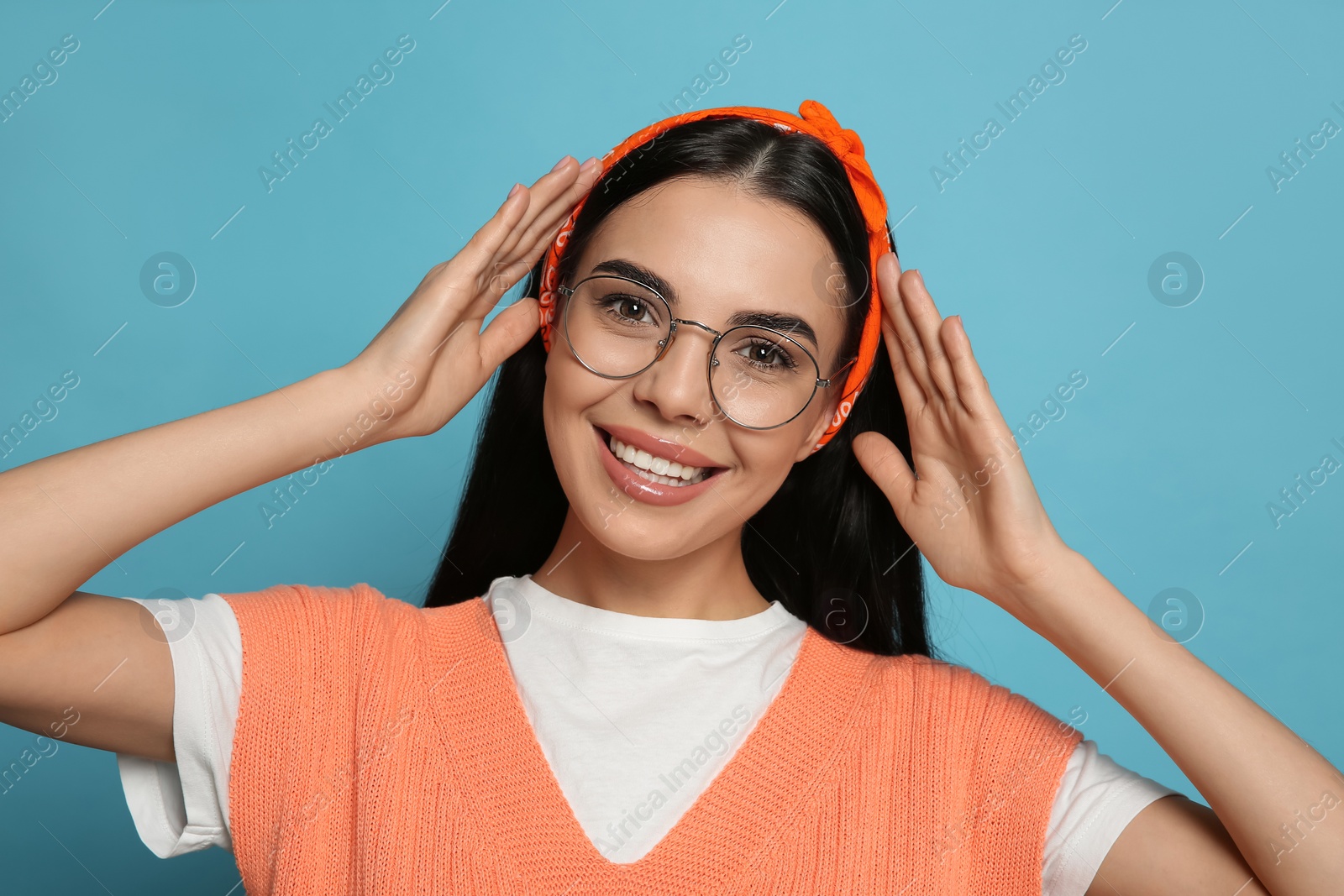 Photo of Young woman wearing stylish bandana on light blue background