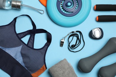 Photo of Flat lay composition with sports equipment on light blue background