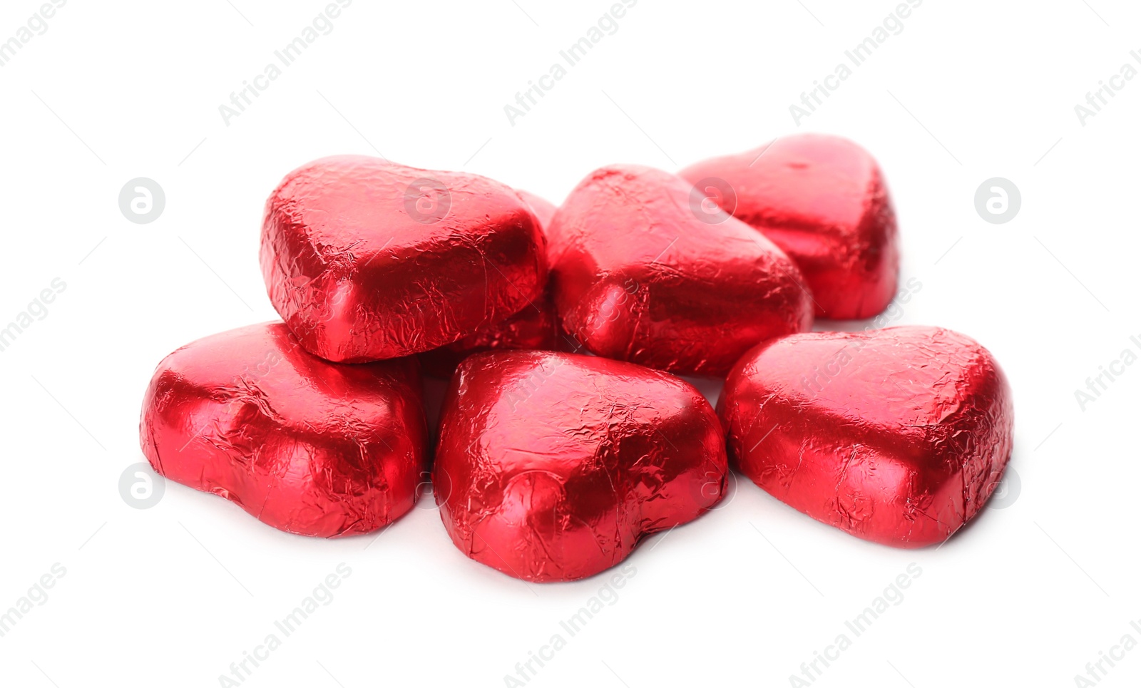 Photo of Heart shaped chocolate candies in red foil on white background