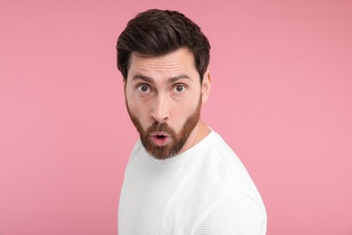 Portrait of surprised man on pink background