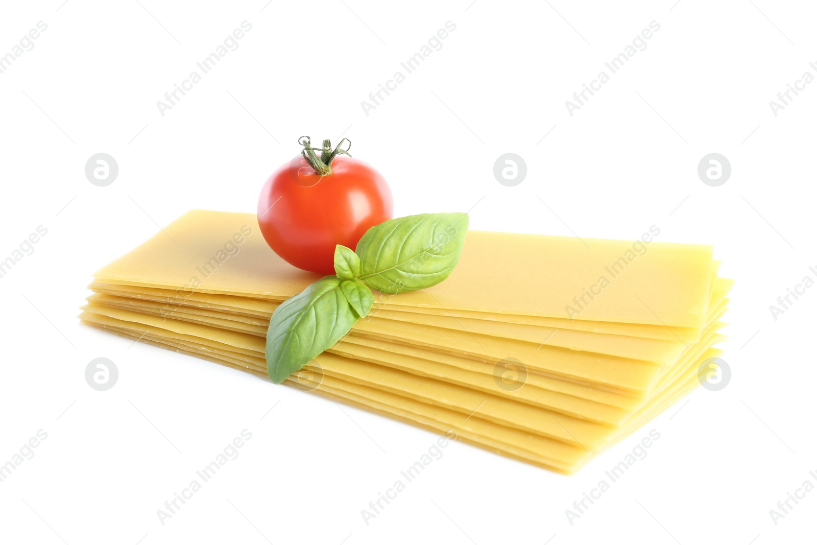 Photo of Uncooked lasagna sheets, tomato and basil on white background