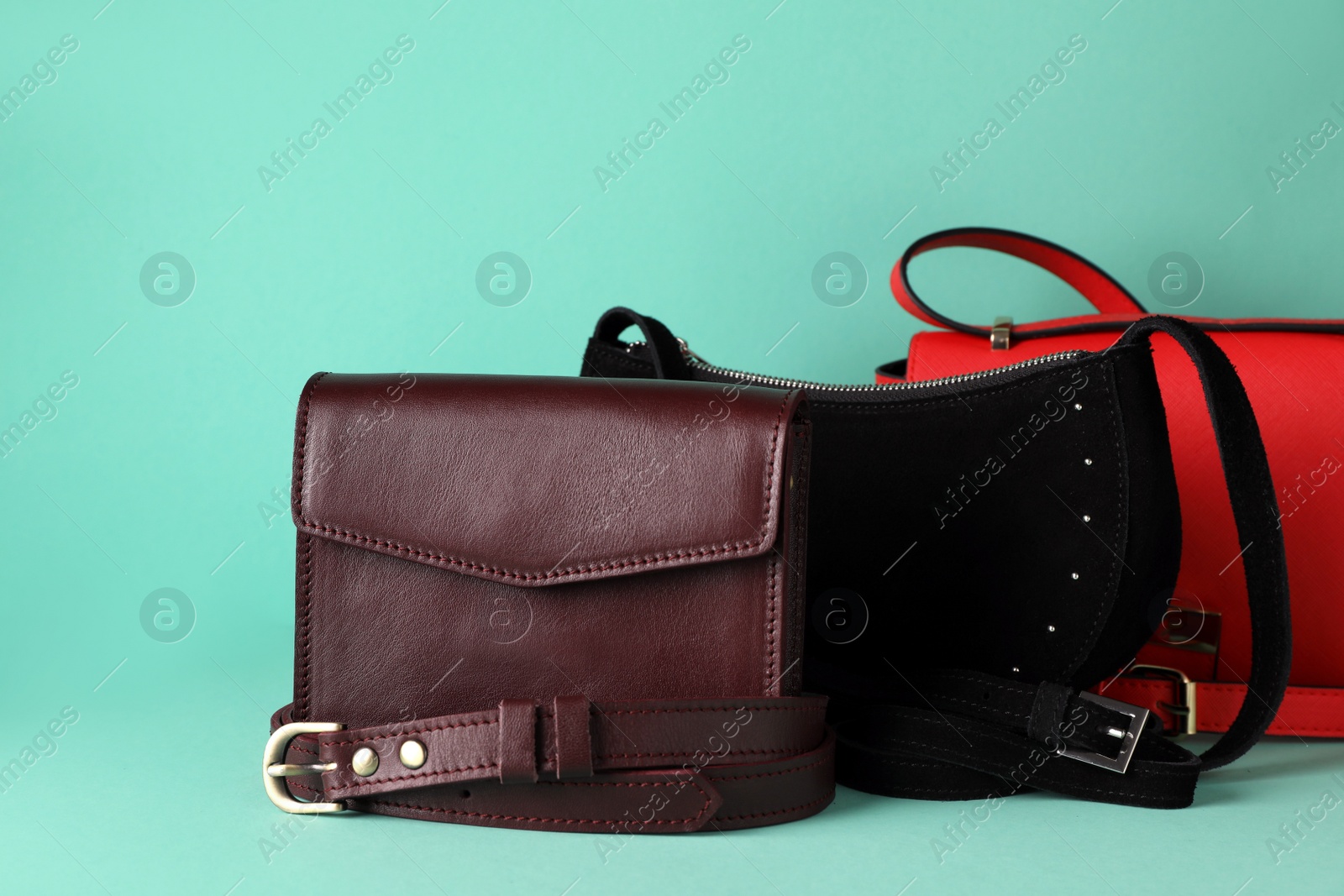 Photo of Different stylish woman's bags on turquoise background