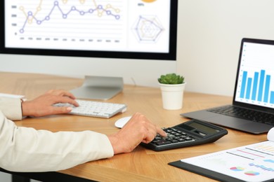 Photo of Accountant working at wooden desk in office, closeup