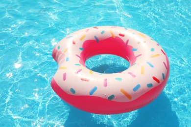 Inflatable ring floating in swimming pool on sunny day