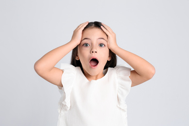 Portrait of cute little girl on light grey background