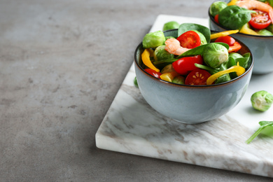 Photo of Tasty salad with Brussels sprouts on grey table. Space for text