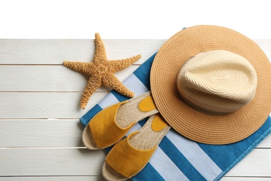 Photo of Beach accessories on white wooden table, flat lay