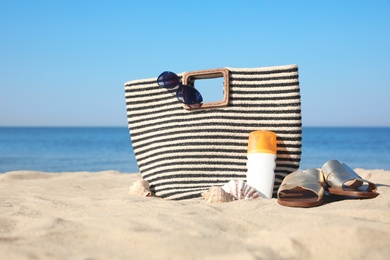 Photo of Stylish beach accessories on sandy sea shore