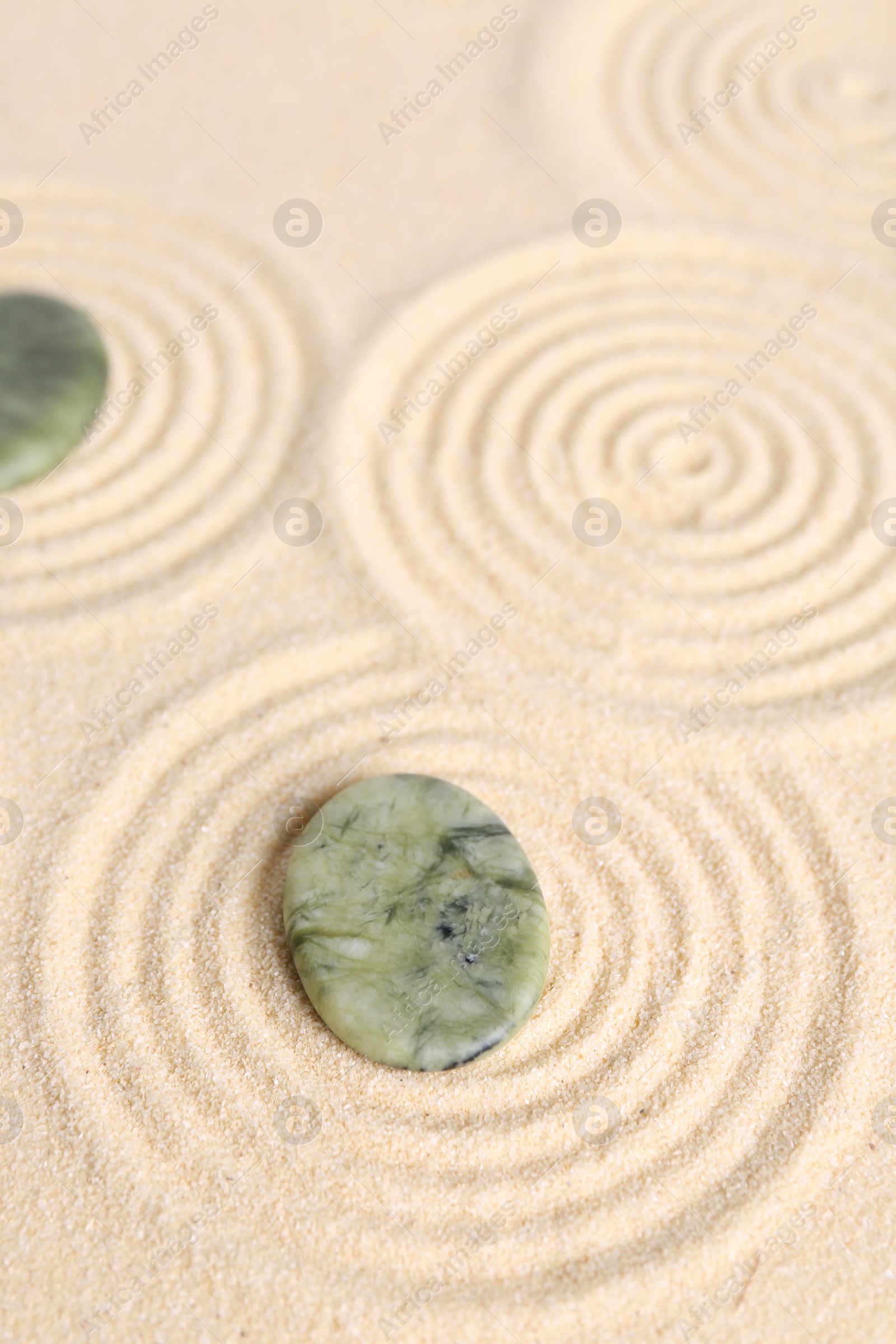 Photo of Zen garden stones on beige sand with pattern