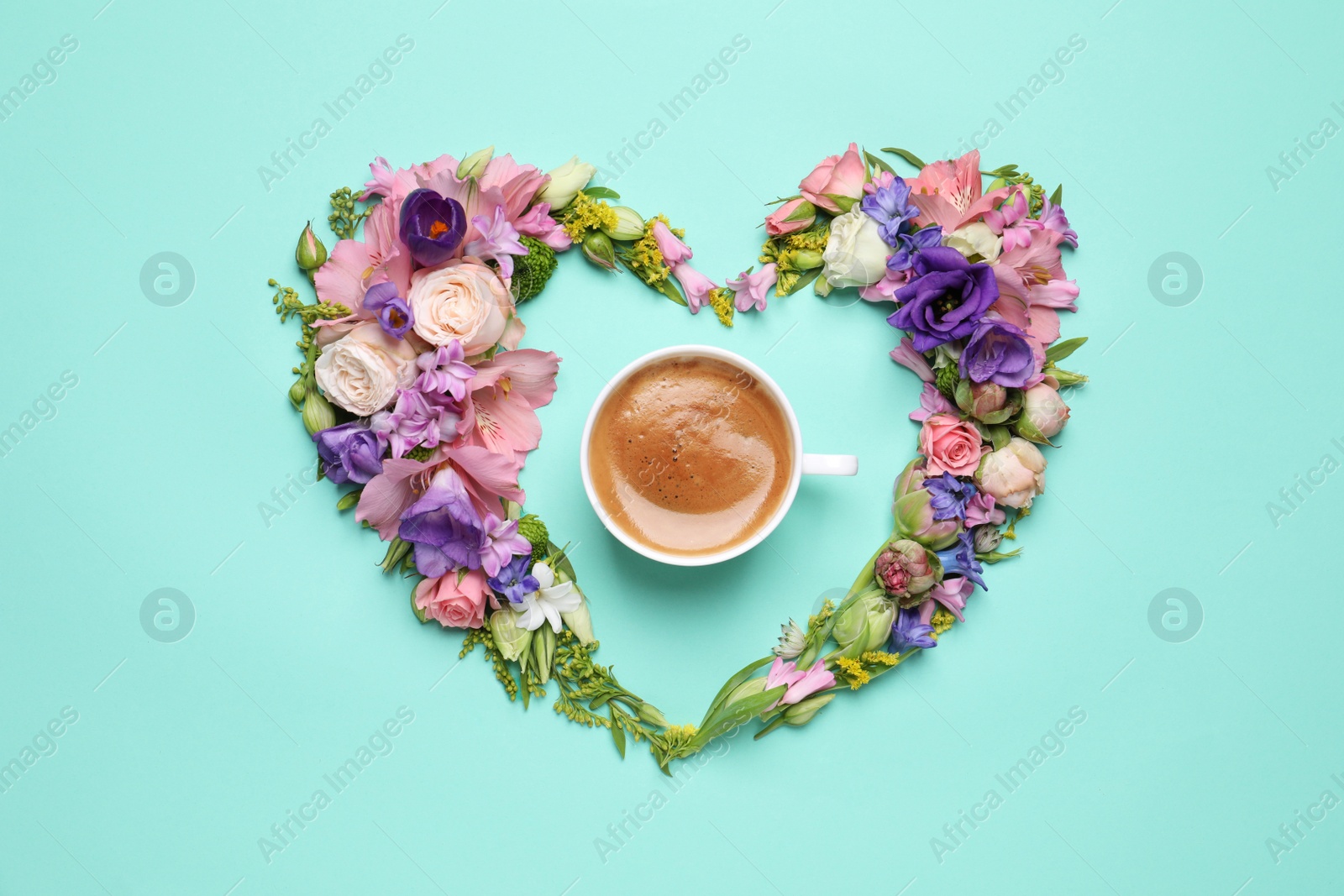 Photo of Beautiful heart shaped floral composition with cup of coffee on turquoise background, flat lay