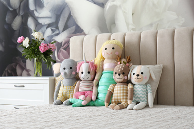 Photo of Different funny toys on bed. Decor for children's room interior