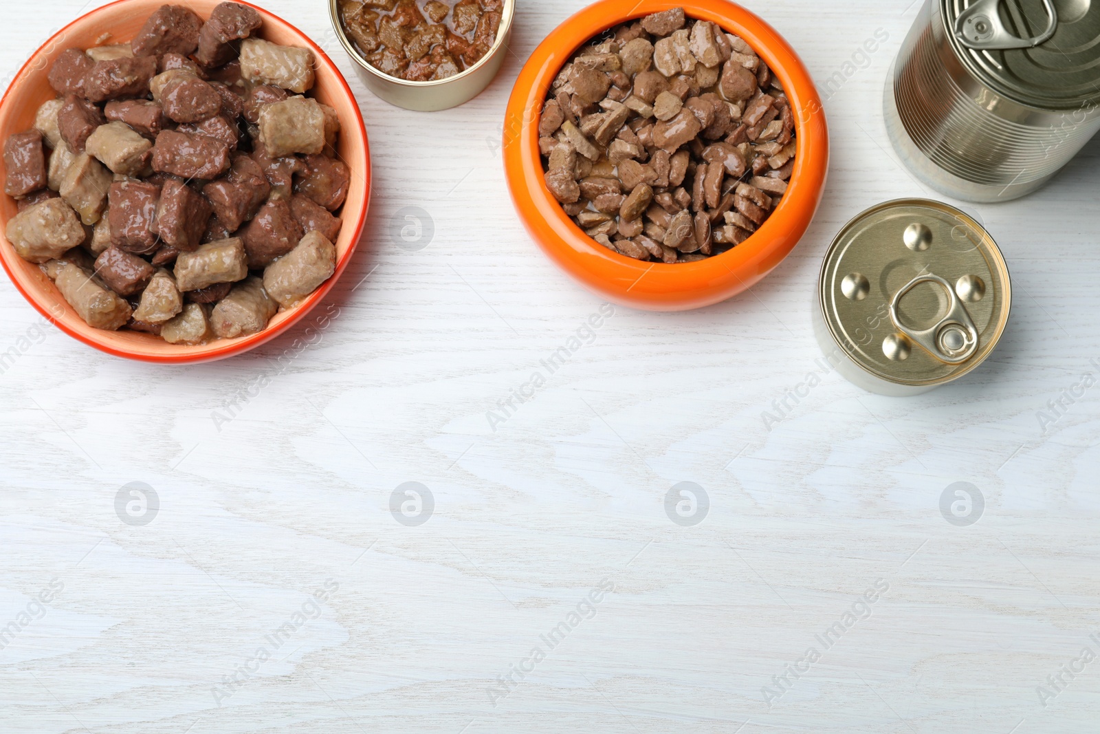 Photo of Wet pet food on white wooden table, flat lay. Space for text