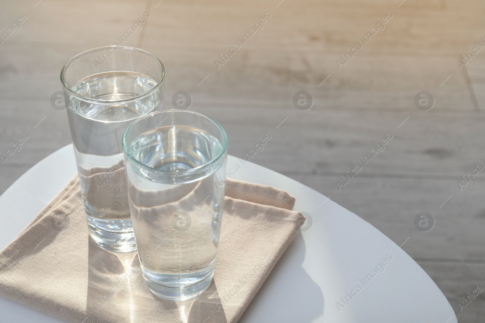 Photo of Glasses with pure water on table indoors. Space for text