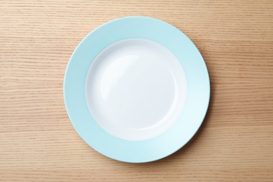 Photo of Stylish ceramic plate on wooden background, top view