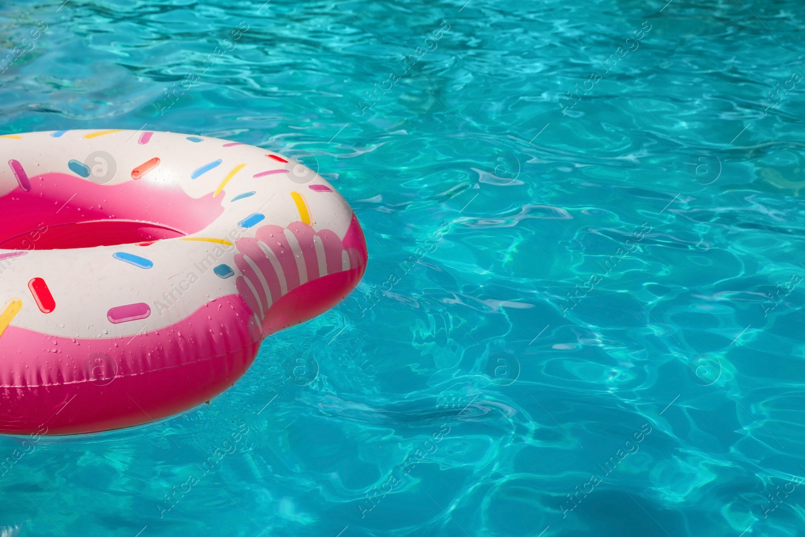 Photo of Inflatable ring floating in swimming pool on sunny day. Space for text