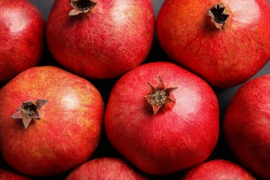 Photo of Ripe red pomegranates on grey background, top view