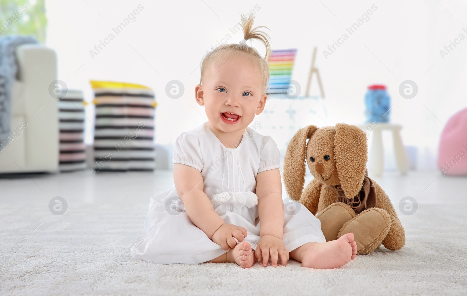 Photo of Adorable baby girl with cute toy at home