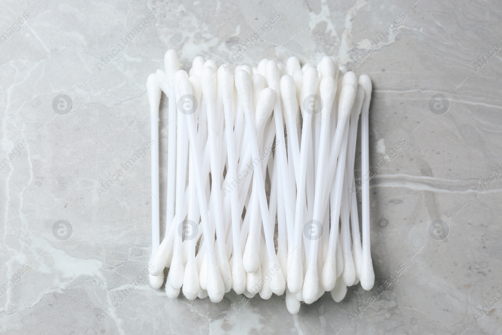 Photo of Many cotton buds on light grey marble table, flat lay