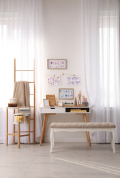 Photo of Stylish room interior with creative workplace near white wall