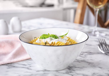 Photo of Delicious pasta with sauce served on white marble table