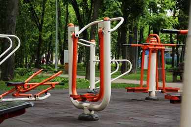 Photo of Empty outdoor gym with air walker, push up bars, rowing machine and double abductor