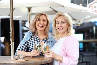 Mature women with drinks at outdoor cafe