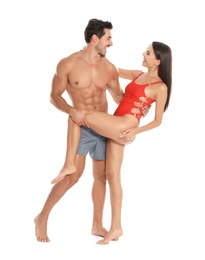 Photo of Young attractive couple in beachwear dancing on white background