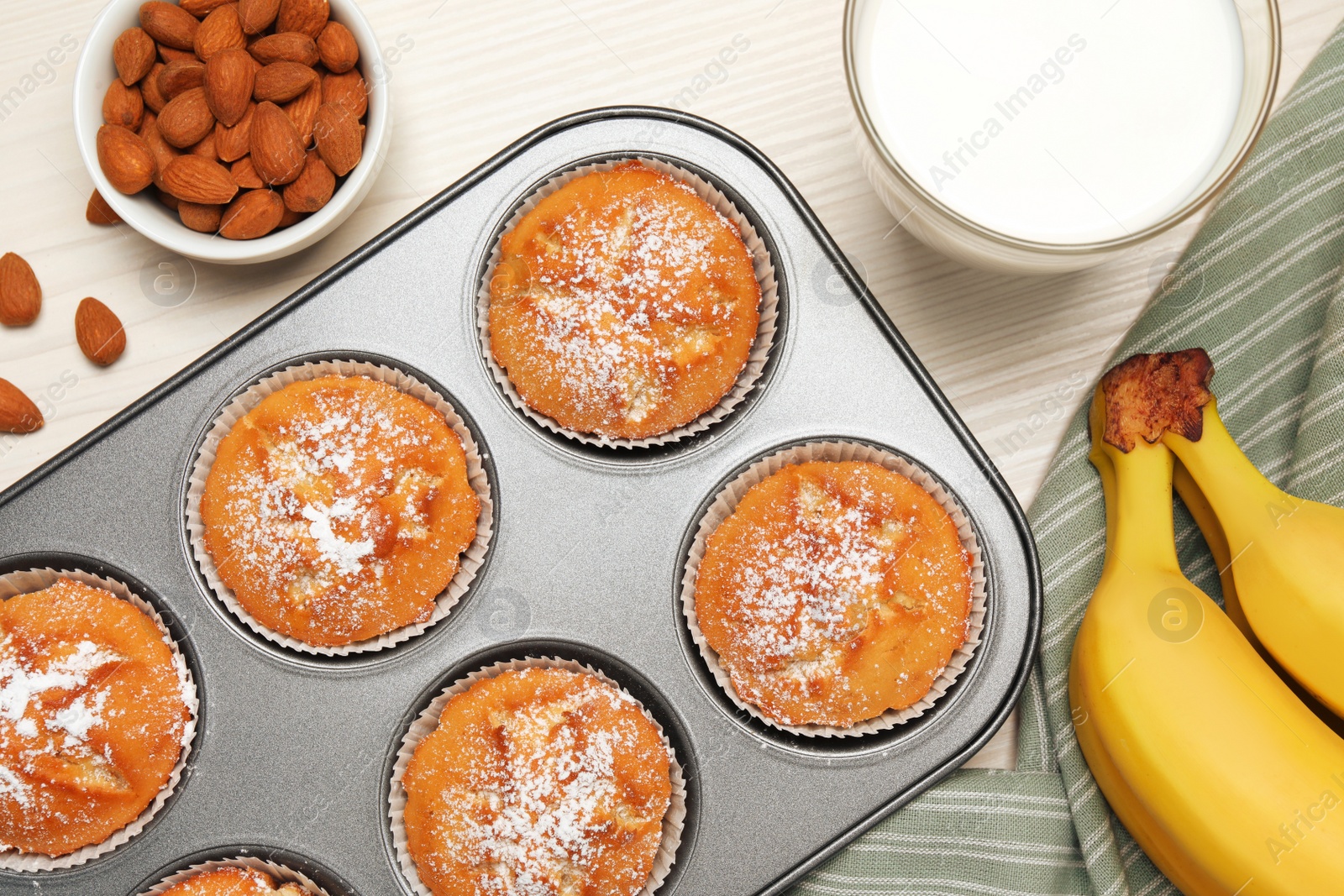 Photo of Flat lay composition with homemade banana muffins and milk on white wooden table