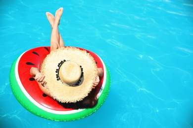 Photo of Young woman with inflatable ring in blue swimming pool
