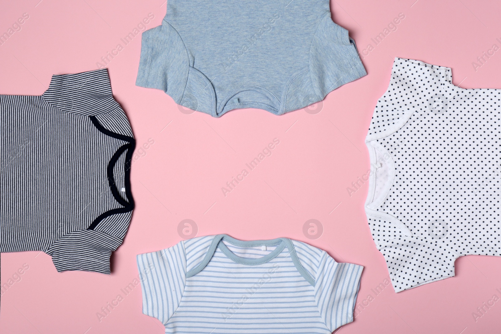 Photo of Frame of cute baby onesies on color background, flat lay. Space for text
