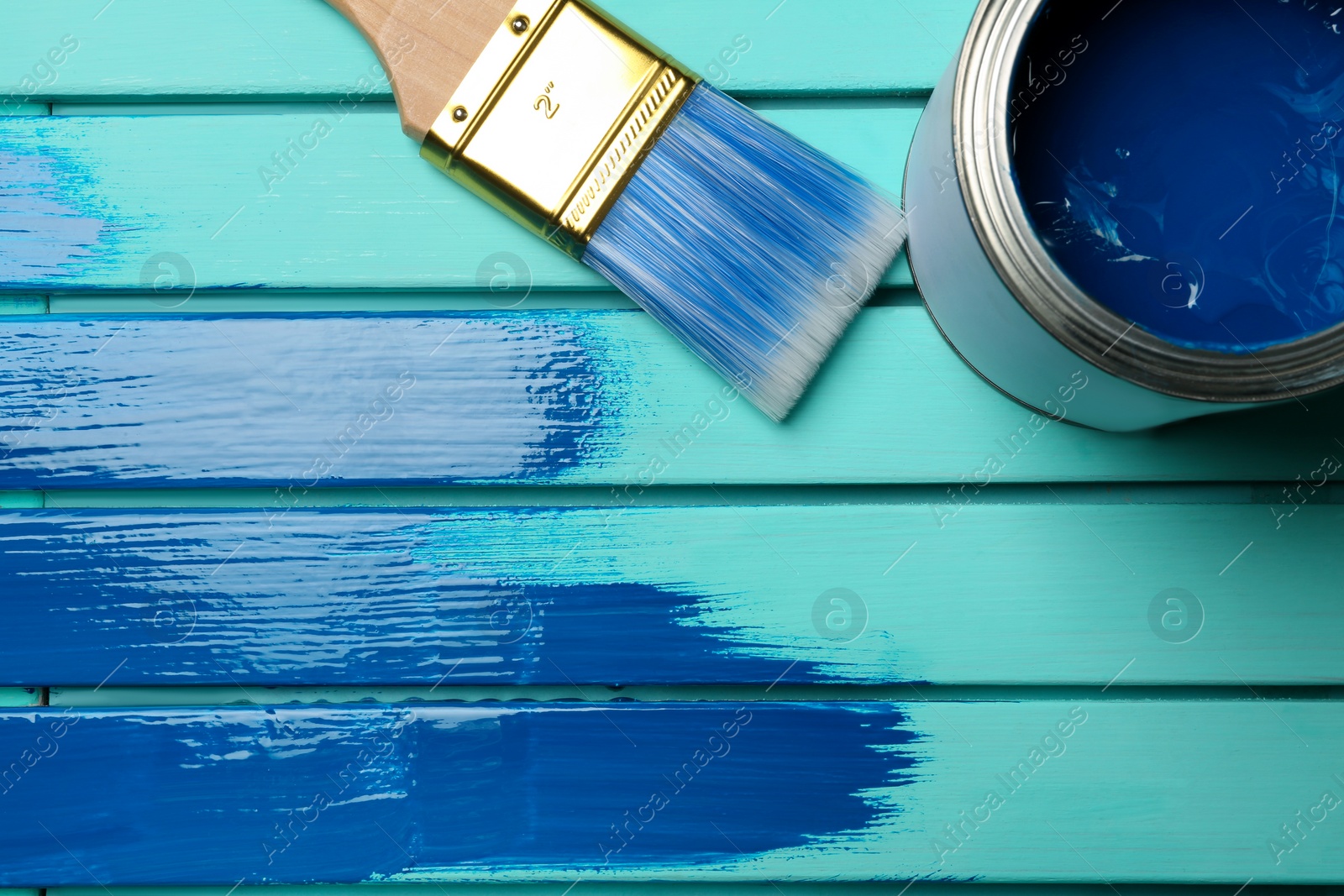 Photo of Paint can, brush and stroke on blue wooden background, top view. Space for text