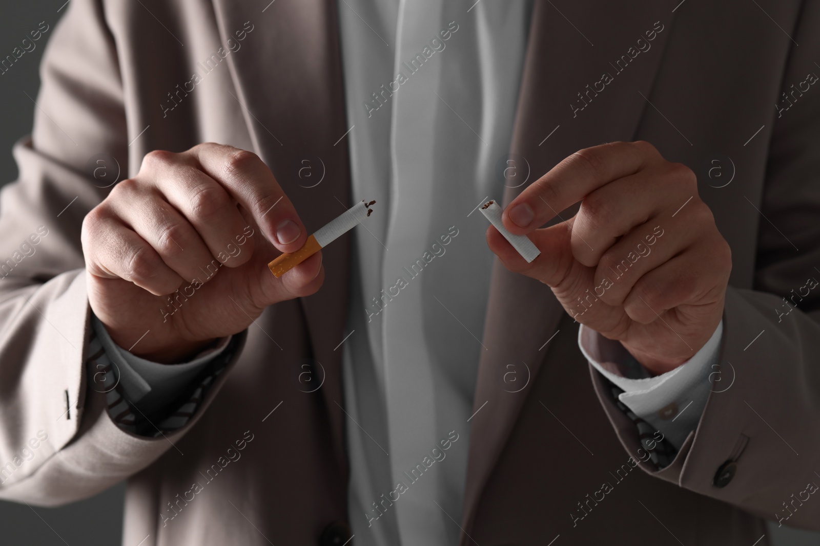 Photo of Stop smoking concept. Man holding pieces of broken cigarette, closeup