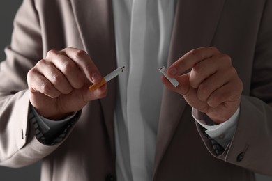 Stop smoking concept. Man holding pieces of broken cigarette, closeup