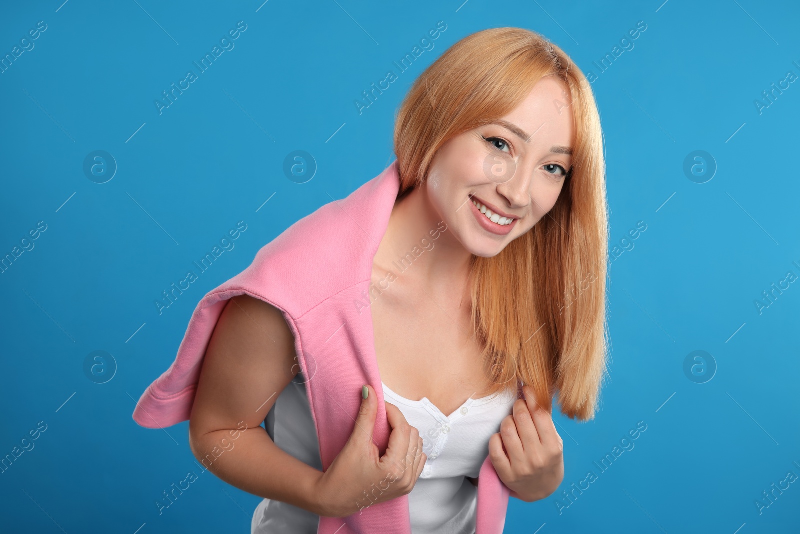 Photo of Beautiful young woman with blonde hair on blue background