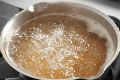 Photo of Cooking pasta in pot on stove, closeup view